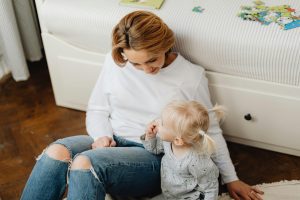 mother and little girl sitting on the floor
