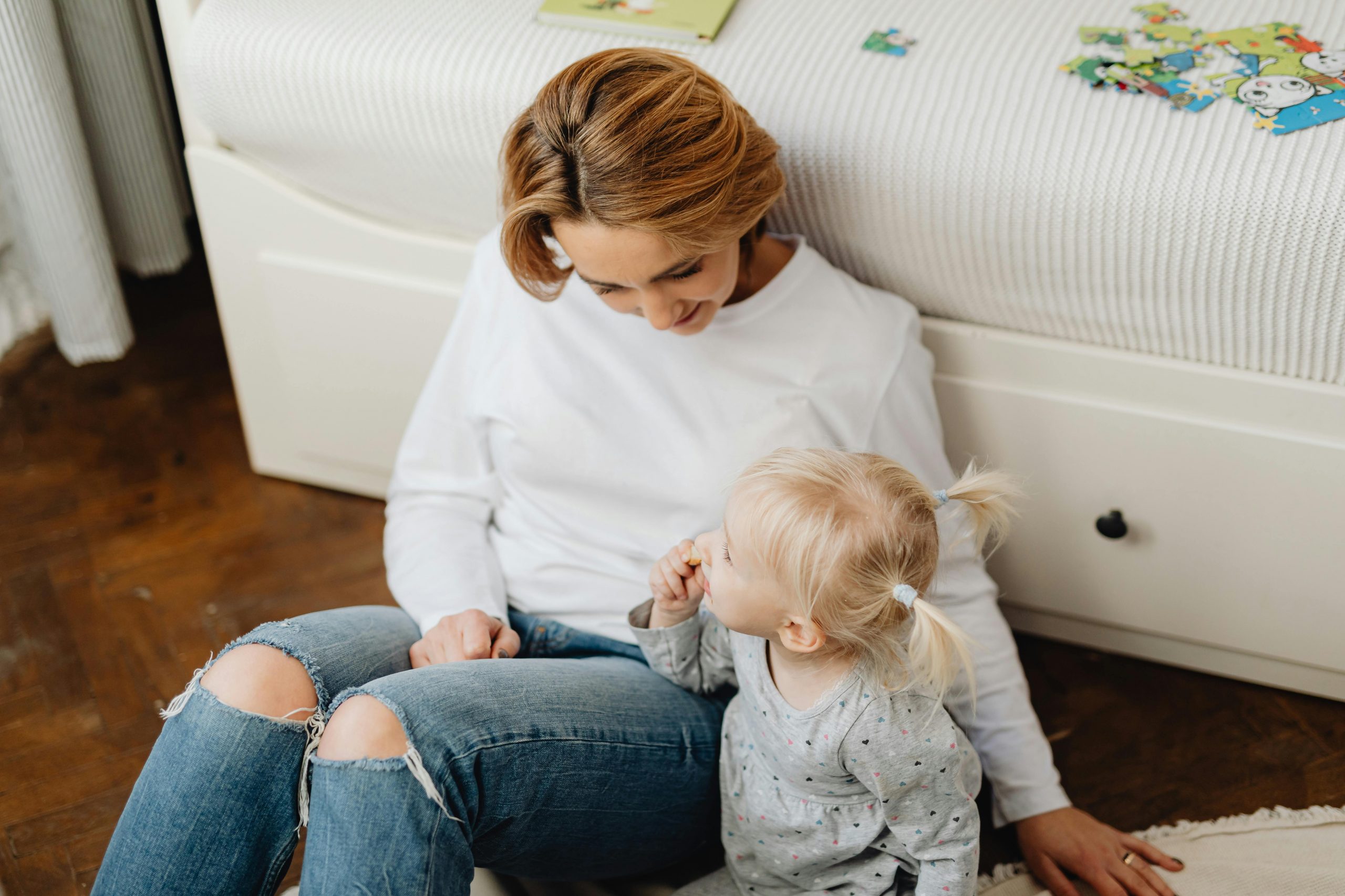 mother and little girl sitting on the floor, talking
